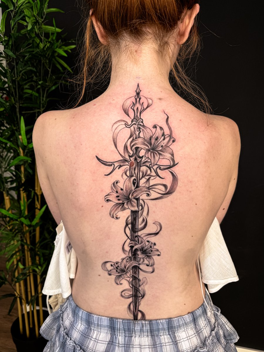 Tatuagem fine line floral na coluna